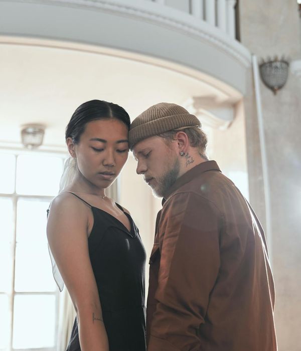 Woman performing a fluid, gentle movement in a bright space.